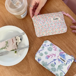 Florale Make-up-Taschen aus Segeltuch auf einem Holztisch bei einer Teestunde