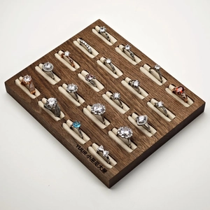 Walnut wood display tray with assorted assorted crystal and zircon rings in various cuts