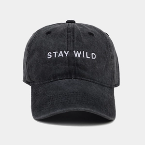 Detail of Stay Wild white embroidery on vintage washed black cotton baseball cap