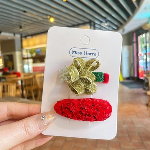 Gros plan sur des barrettes de fête rouges et dorées pailletées avec détail de flocon