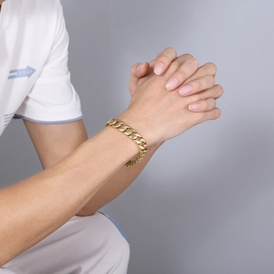 Nahaufnahme des goldenen Edelstahl-Panzerarmbands am Handgelenk mit 12mm flachen Gliedern