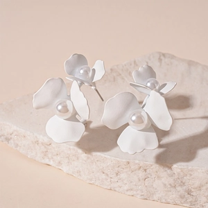 Minimalist white flower stud earrings with faux pearl center on natural stone base