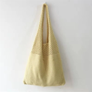 Detail of yellow knitted tote bag with intricate hollow-out texture and soft cotton material