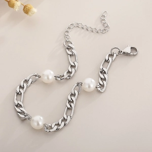 Detail of silver Figaro chain bracelet with three white pearls and lobster clasp