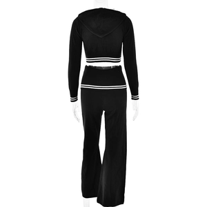 Detail view of black knit two-piece set featuring white stripes on hoodie hem and flared pants
