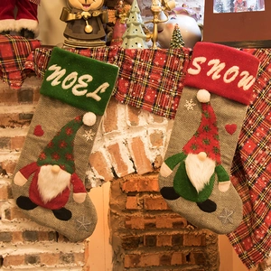 Christmas stockings with faceless gnome embroidery hanging on fireplace mantle