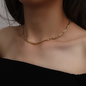 Detailed view of the 18K gold Figaro link chain necklace on a female model neck