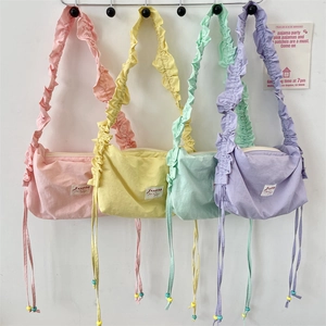 Detail of four vibrant pleated nylon crossbody bags with colorful drawstring beads