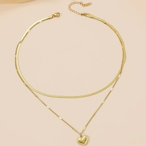 Detail of gold double-layer necklace with heart pendant engraved Love You and lobster clasp