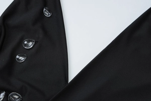 Détail de la robe en maille noire avec perles de cristal en forme de gouttelette