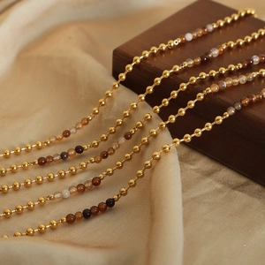 Collana vintage con perline dorate e pietre naturali su tessuto di raso giallo