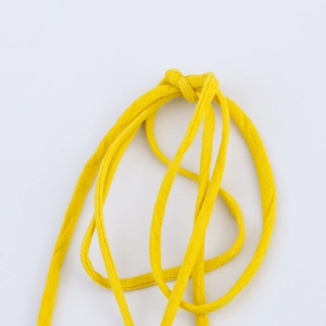 Detail of yellow woven cotton drawstring cord with textured finish for summer dresses
