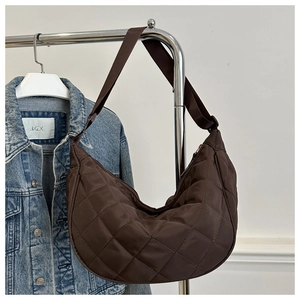 Détail du sac demi-lune matelassé marron foncé en nylon avec large bandoulière textile