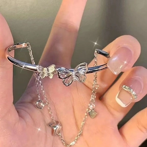 Silver butterfly bracelet with tassel and heart charms in a sparkling metallic finish