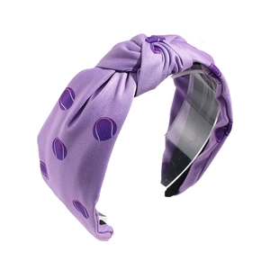 Purple fabric knotted headband featuring white tennis patterns on a clean white background