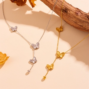 Detail view of gold and silver double-sided butterfly necklaces with steel ball tassels