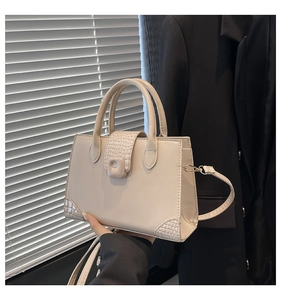 Detail of cream white faux crocodile pattern texture on a stylish square tote handbag