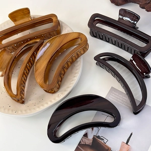 Detailed view of tortoiseshell acrylic hair clips with crescent and rectangle shapes
