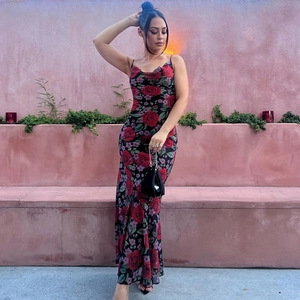 Détail de robe longue noire fleurie avec des roses rouges et col en V élégant et chic