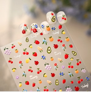 Primo piano di adesivi 3D per nail art con frutta colorata e coccinelle in rilievo