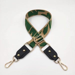 Close-up of adjustable khaki and green woven strap with black leather and gold hardware