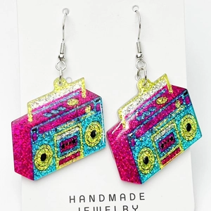 Macro shot of colorful glitter resin earrings in retro radio design on white card