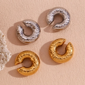 Dettaglio di orecchini placcati oro 18K e argento con trama trapuntata a pelle di serpente