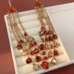 Detailed macro view of vintage multi-layer necklace with orange stones in a beige jewelry box
