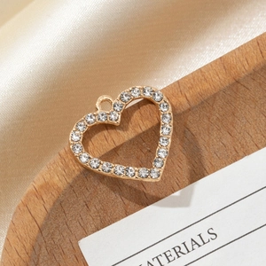 Close-up of gold heart-shaped charm with pavé crystals for DIY jewelry making