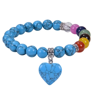 Detailed shot of turquoise bead bracelet with chakra stones and a heart pendant charm