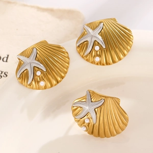 Close-up of golden scallop shell brooches with silver starfish and white pearls