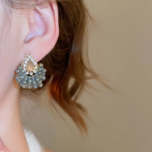 Détail des boucles d'oreilles goutte d'eau avec pierre ambre et franges de perles