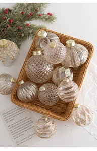 Close-up of champagne transparent Christmas ornaments with gold glitter in a woven basket