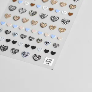 Macro shot of 3D embossed heart nail stickers with zebra stripes and glitter textures