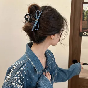 Pince à cheveux avec nœud en denim bleu portée sur un chignon de style coréen