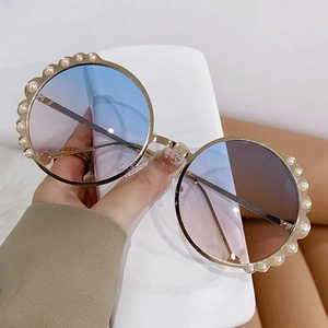 Fashionable round sunglasses with pearls and blue-pink gradient lenses on a gold metal frame