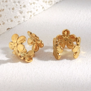 Vue macro de boucles d'oreilles clips fleurs en acier inoxydable doré à cinq pétales