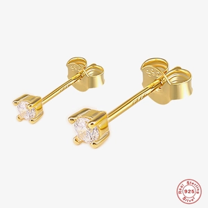 Detail view of gold S925 sterling silver stud earrings with round cut four-prong solitaire