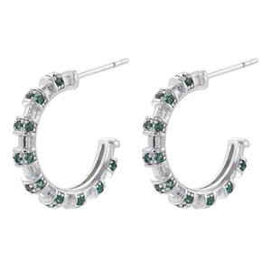 Detailed view of C-shaped earrings with inlaid green zircons in silver finish