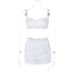 Close-up of white satin two-piece set featuring ruffled tube top and high waist shorts