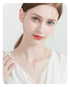 Elegant gold necklace featuring a classic round solitaire pendant worn on a model