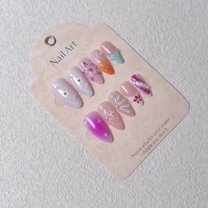 Detail of almond press-on nails with 3D floral relief, pearls, and pastel gradients