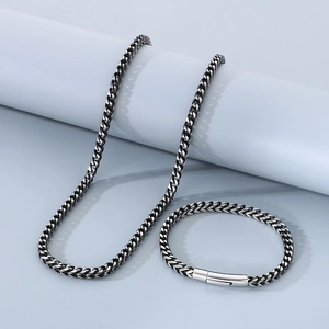 Gros plan sur l'ensemble collier et bracelet en chaîne cubaine vintage en acier noir