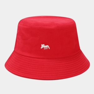 Detailed close-up of white fox embroidery on a red cotton bucket hat with stitching