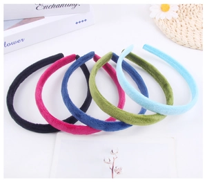 Flat lay of colorful plush headbands in six vibrant shades on a white background