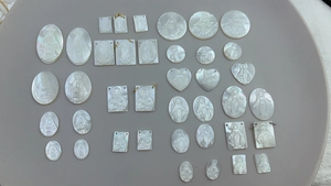 Macro detail of assorted natural mother of pearl religious Guadalupe pendants in various shapes