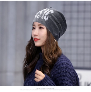 Close-up of deep gray slouchy beanie featuring a stylish white NYC graffiti print
