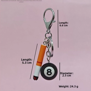 Detail shot of mini billiard ball and cigarette keychain charms with size measurement markers
