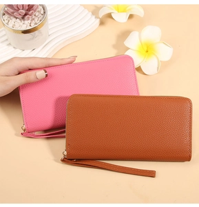 Detail of pink and brown pebble grain leather wallets with gold zippers and wristlets