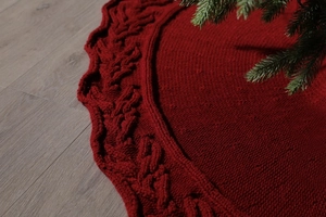 Macro view of red chunky knit Christmas tree skirt with detailed cable patterns